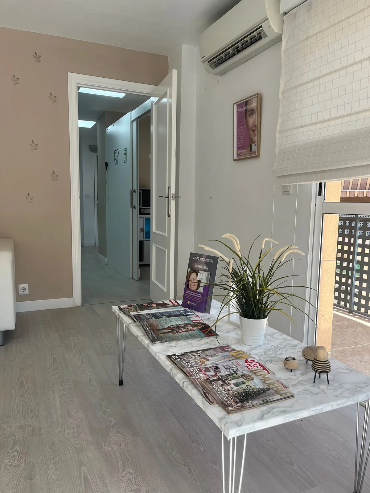 Pasillo de la clínica con la mesa de revistas y la entrada a los gabinetes